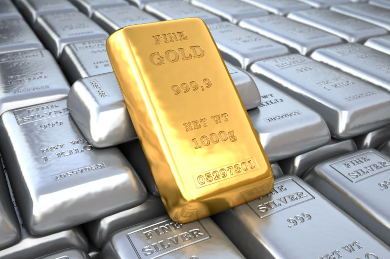 Silver bars lined up in piles with a single gold bar sitting on the top