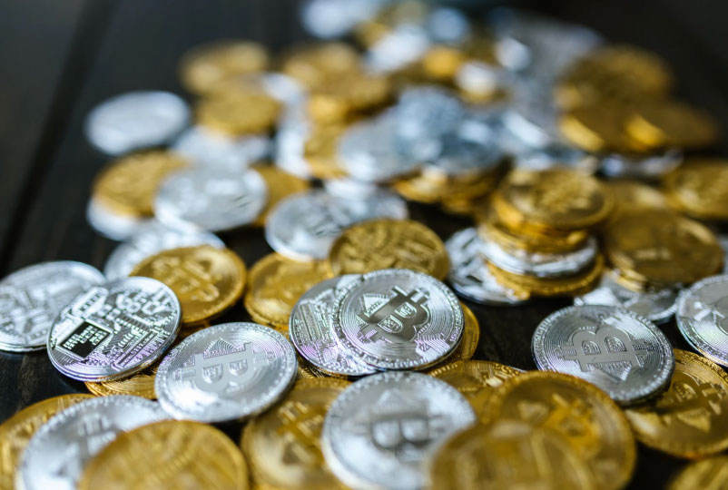 Various gold and silver coins on a black background